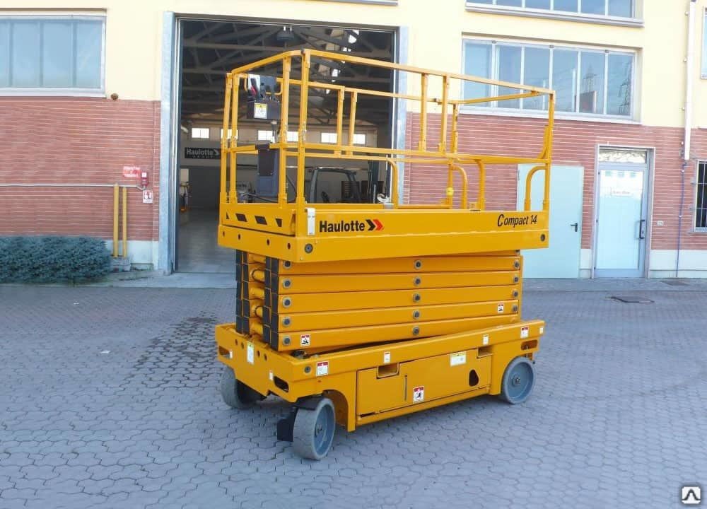 Podnośnik nożycowy Haulotte Compact 14 na placu przed budynkiem