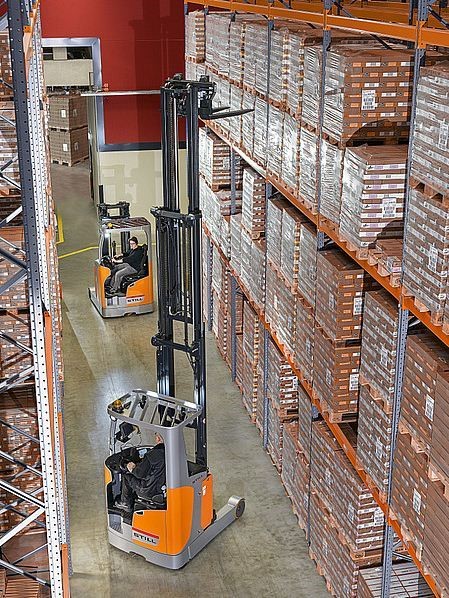 Wąskokorytarzowe reach trucki Still podczas pracy na wysokich regałach w magazynie
