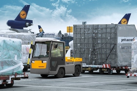 Elektryczny ciągnik Jungheinrich transportuje ładunki na terenie lotniska
